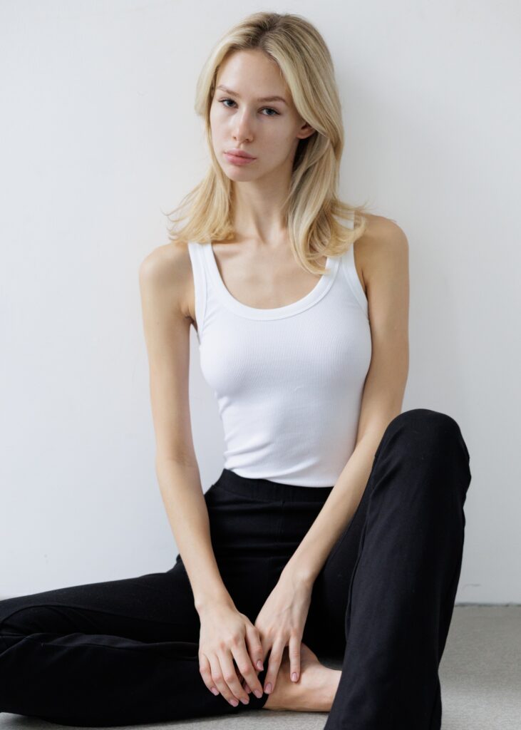 Polas assis d'un mannequin femme habillé en pantalon noir et t-shirt blanc