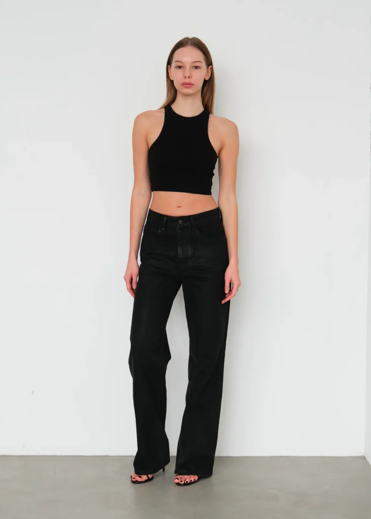 Mannequin femme posant de plein pied en jean et haut noir pour un pola d'agence