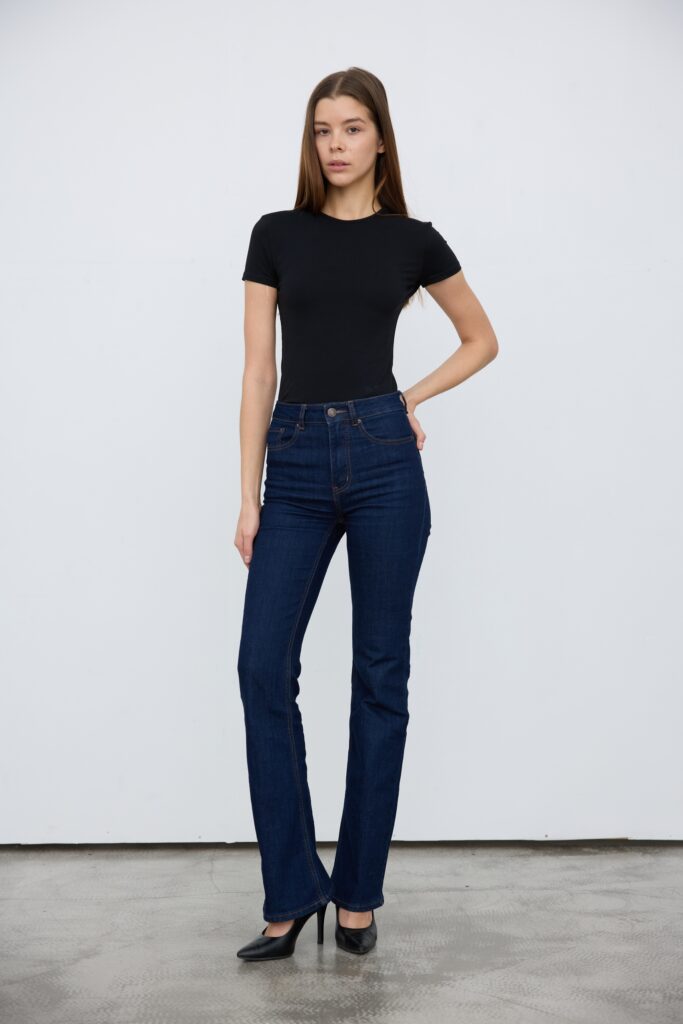 Mannequin femme posant de plein pied en jean brut et t-shirt noir avec des talons pour des polas d'agence